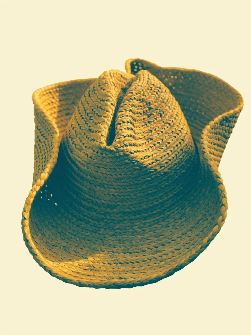 Studio illustrato di un cappello intrecciato dalla tesa asimmetrica.